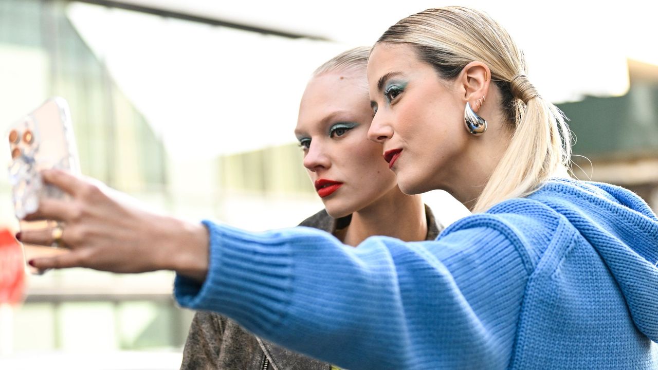 Models wearing blue eyeshadow and a red lip GettyImages-2007249470