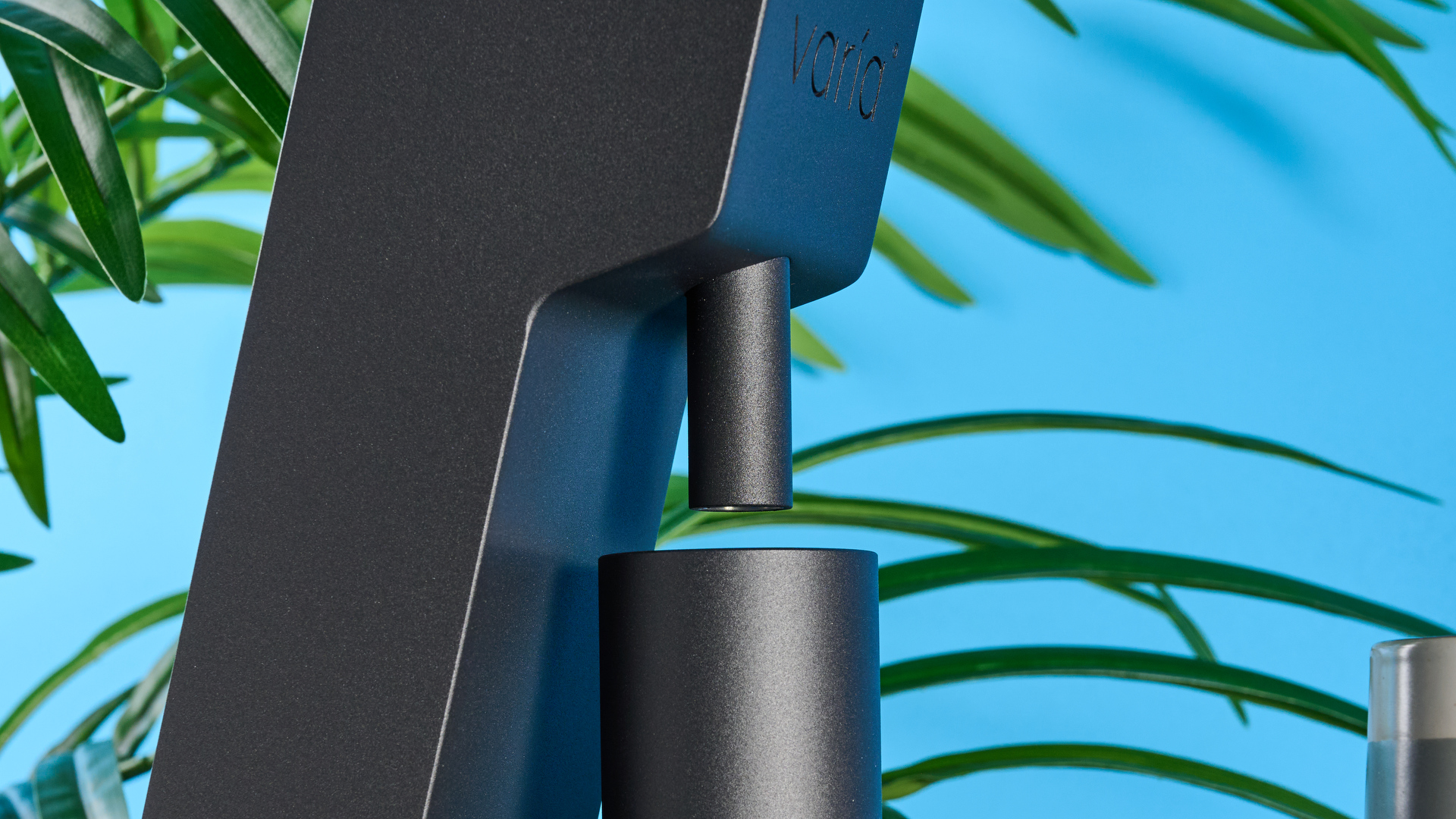 The Varia VS3 coffee grinder in use on a stone surface with a blue background