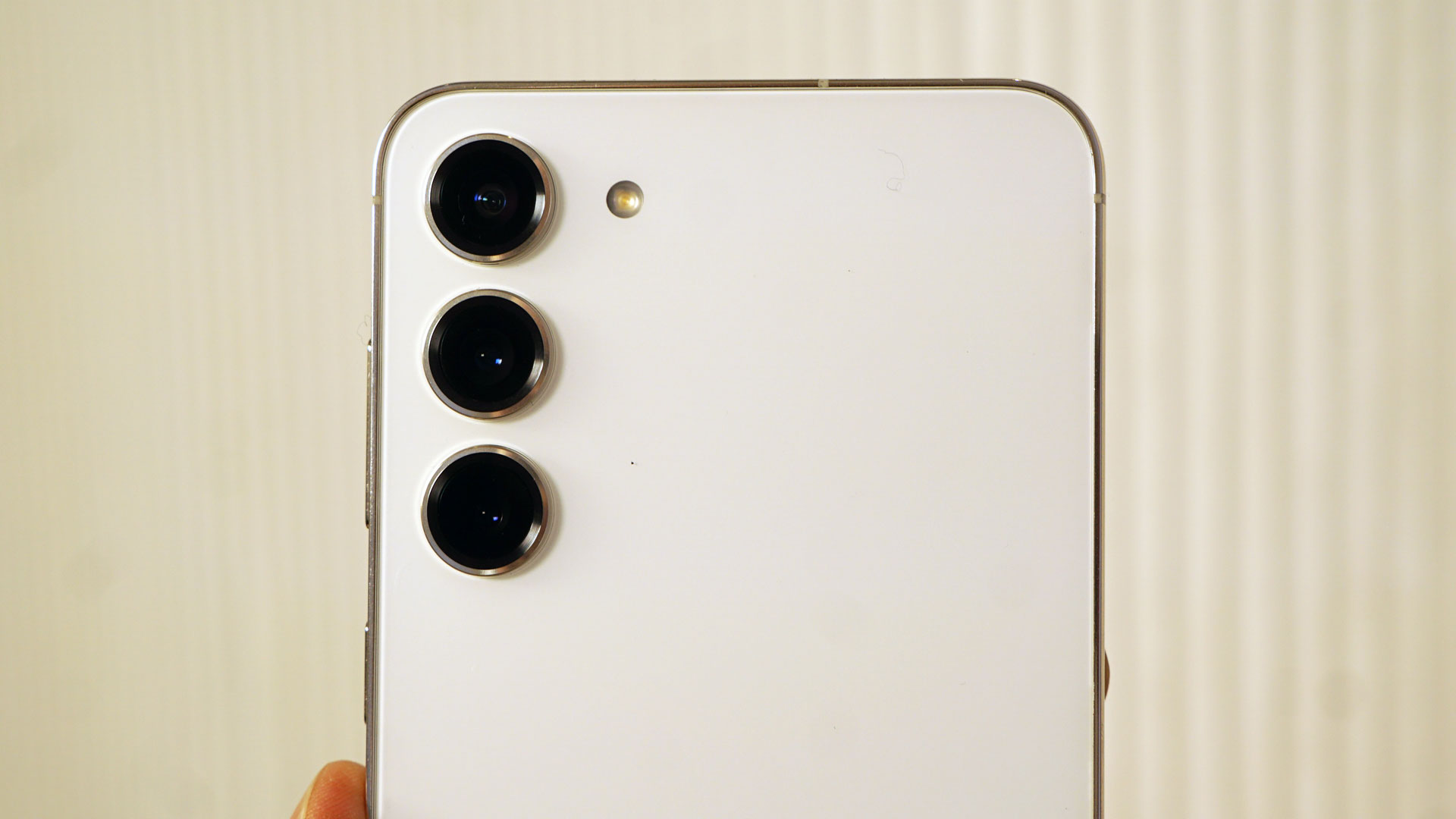 El Samsung Galaxy S23 Plus en blanco, mostrado desde atrás con su conjunto de tres cámaras