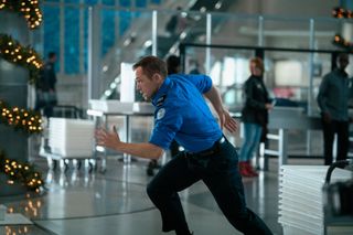 Taron Edgerton as Ethan Kopek running through an airport in the movie carry on