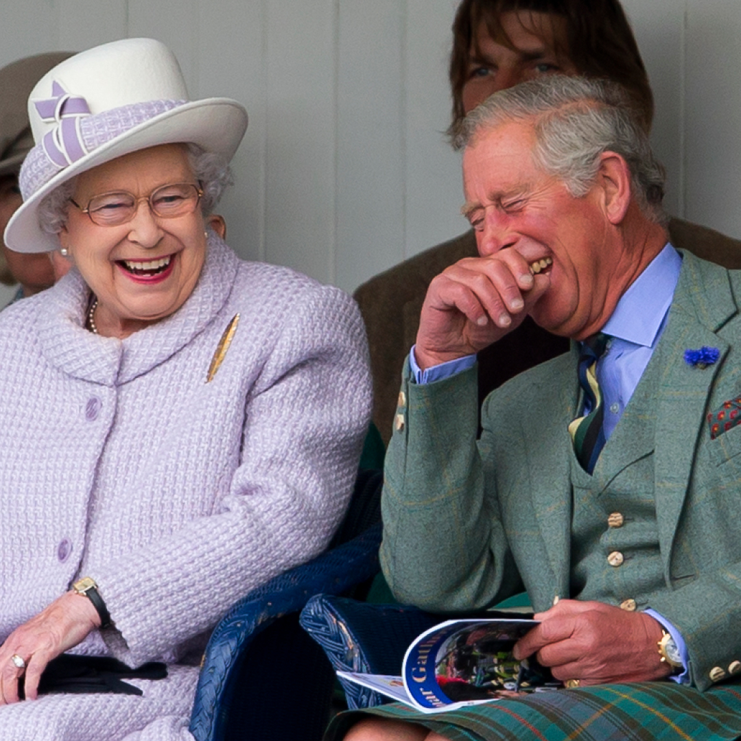 Queen Elizabeth and King Charles sitting next to each other and laughing hysterically