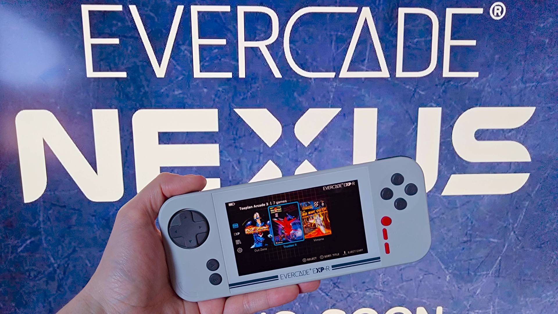 Hand holding Evercade EXP-R handheld in front of Evercade Nexus teaser logo.