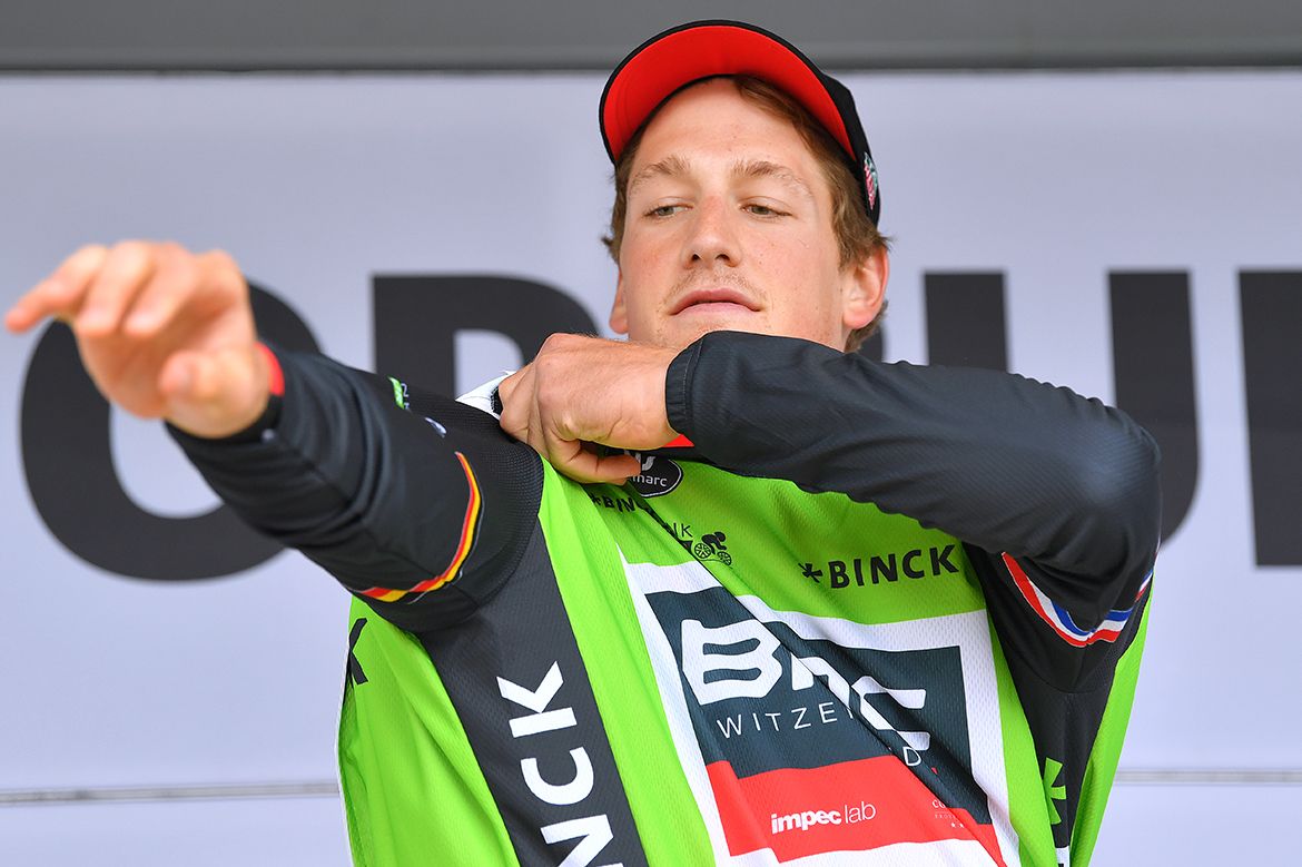 Stefan Kung pulls on the leader's jersey