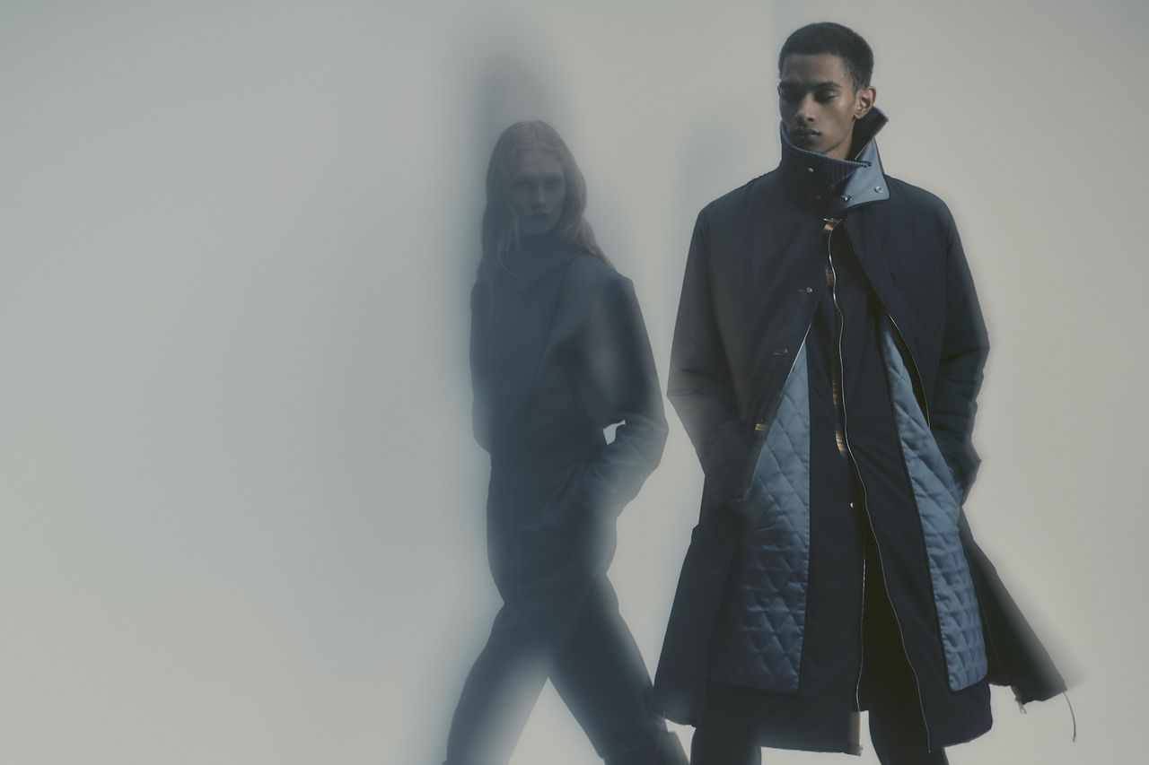 Man and woman in Anest Collective coats on grey background