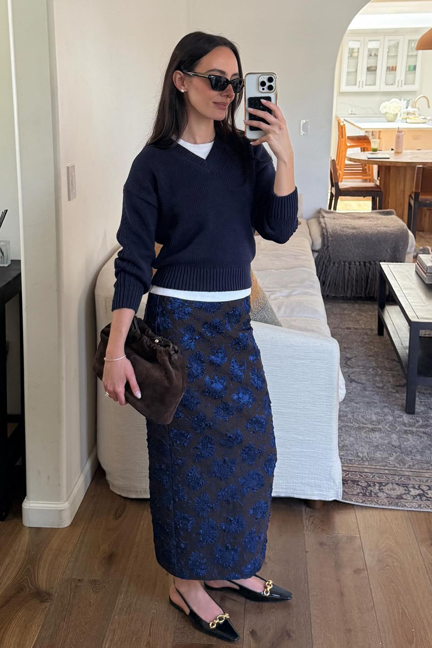 a woman wearing a sweater, and blue texured column skirt