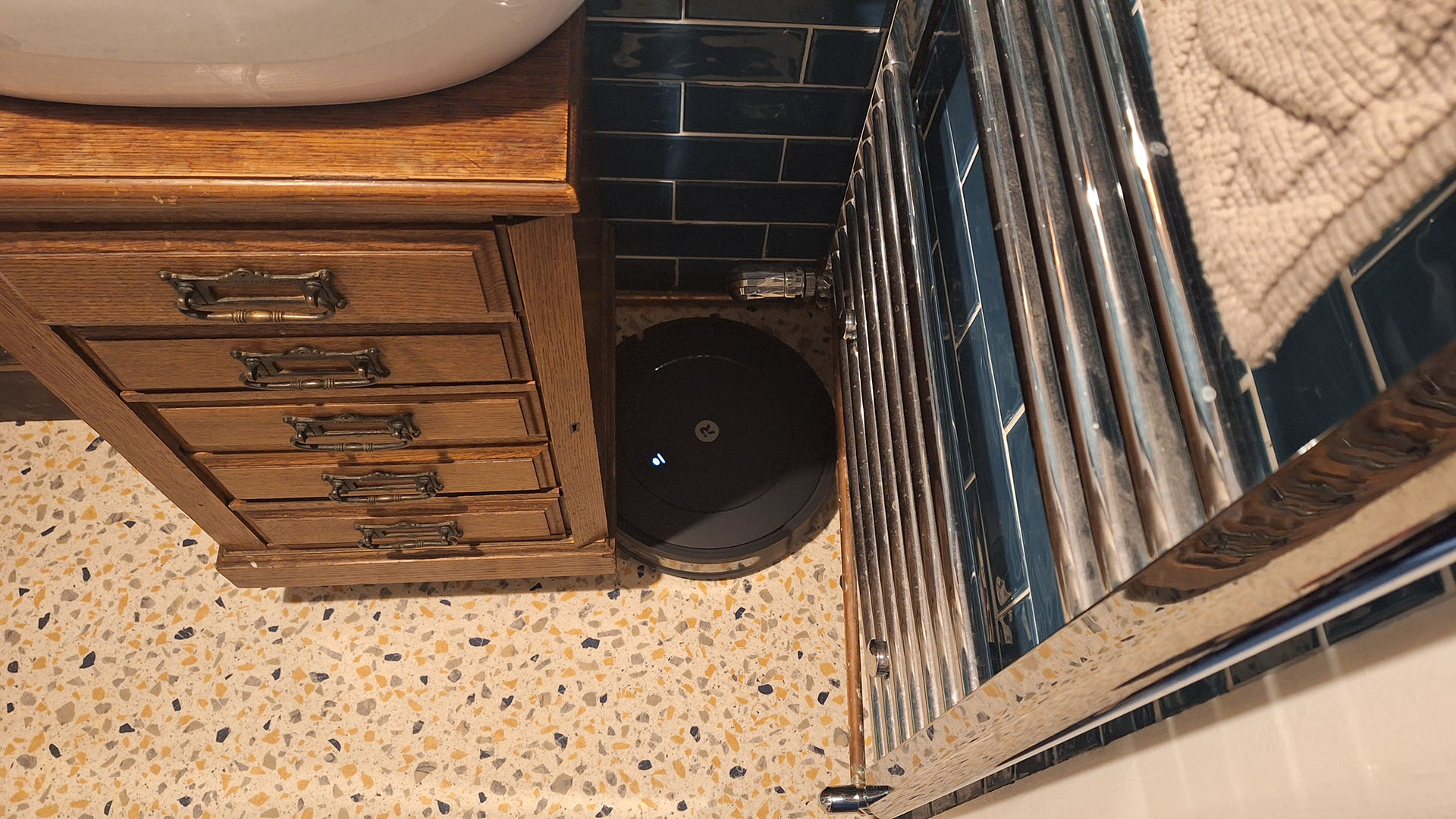 Roomba Combo Essential robot vacuum stuck in the corner of a bathroom