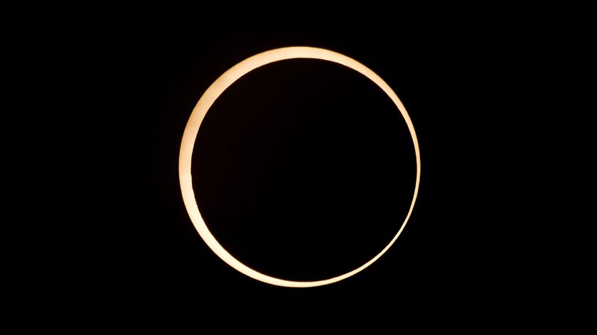 view of annular solar eclipse with moon in the enter obscuring a majority of the sun&#039;s disk, leaving a ring of fire around the outside.