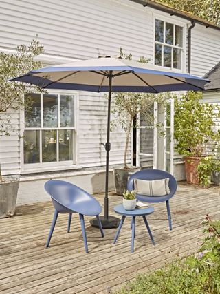 parsol over a blue bistro set on a decked terrace