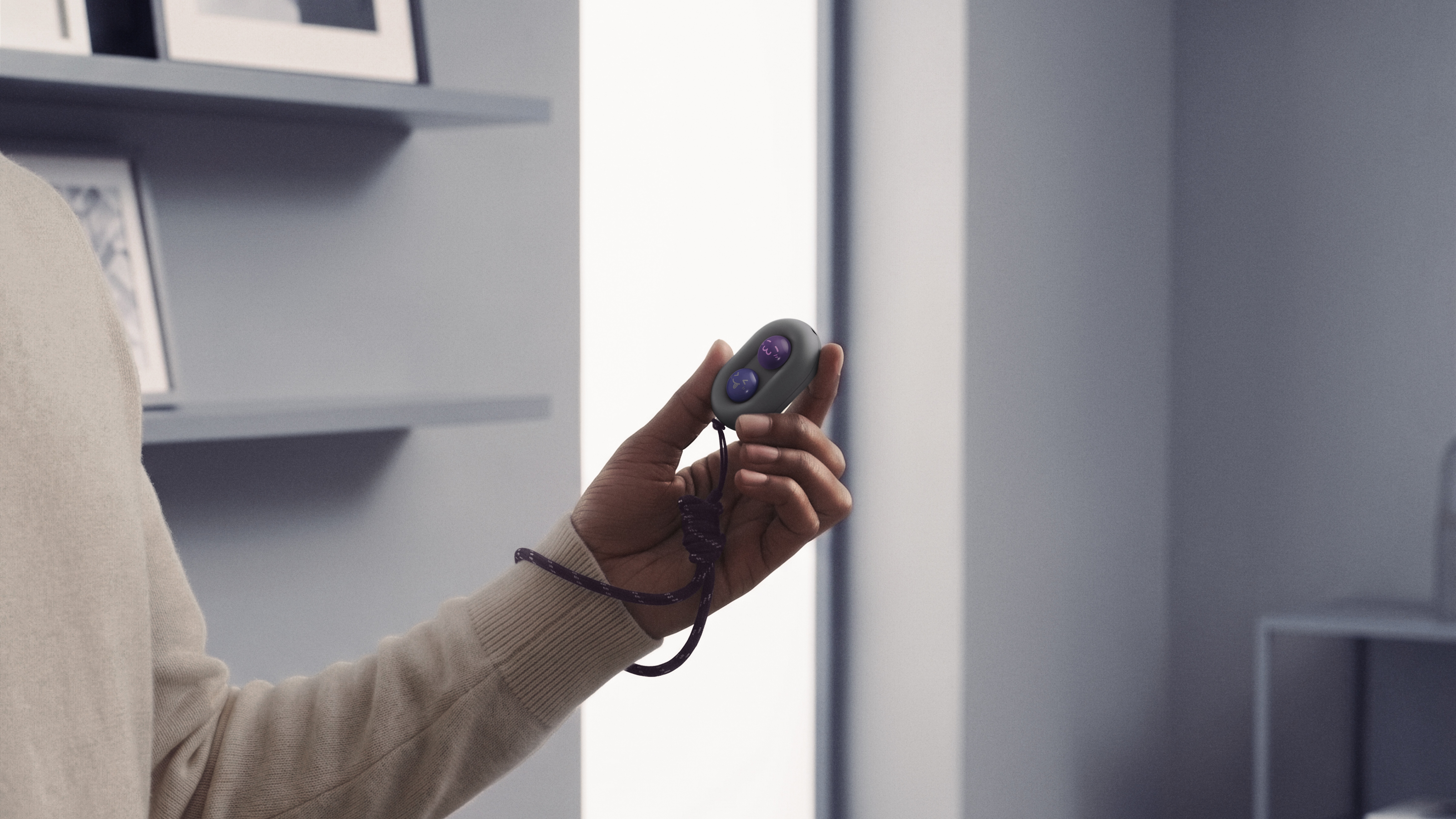 The DuRoBo Moodi in a model's hand, showing off its cute purple and pink emoji caps.