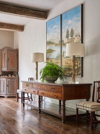 Wooden table, two lamps and two landscape paintings