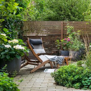 garden with potted plants and relaxing chair