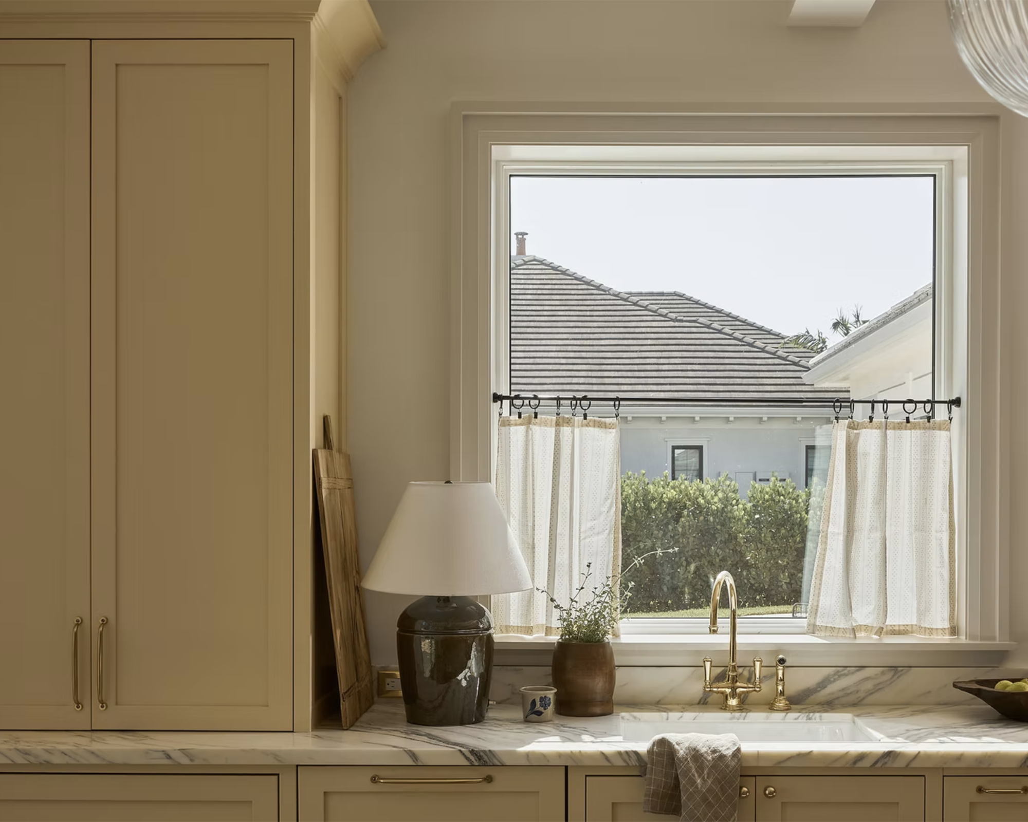 kitchen with cream cabinets and a lamp on a marble worktop