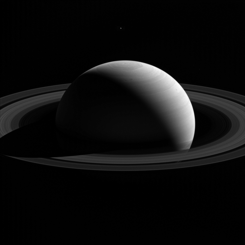 A new image captured from NASA&#039;s Cassini spacecraft shows Saturn&#039;s moon Tethys lingering above the planet&#039;s north pole.