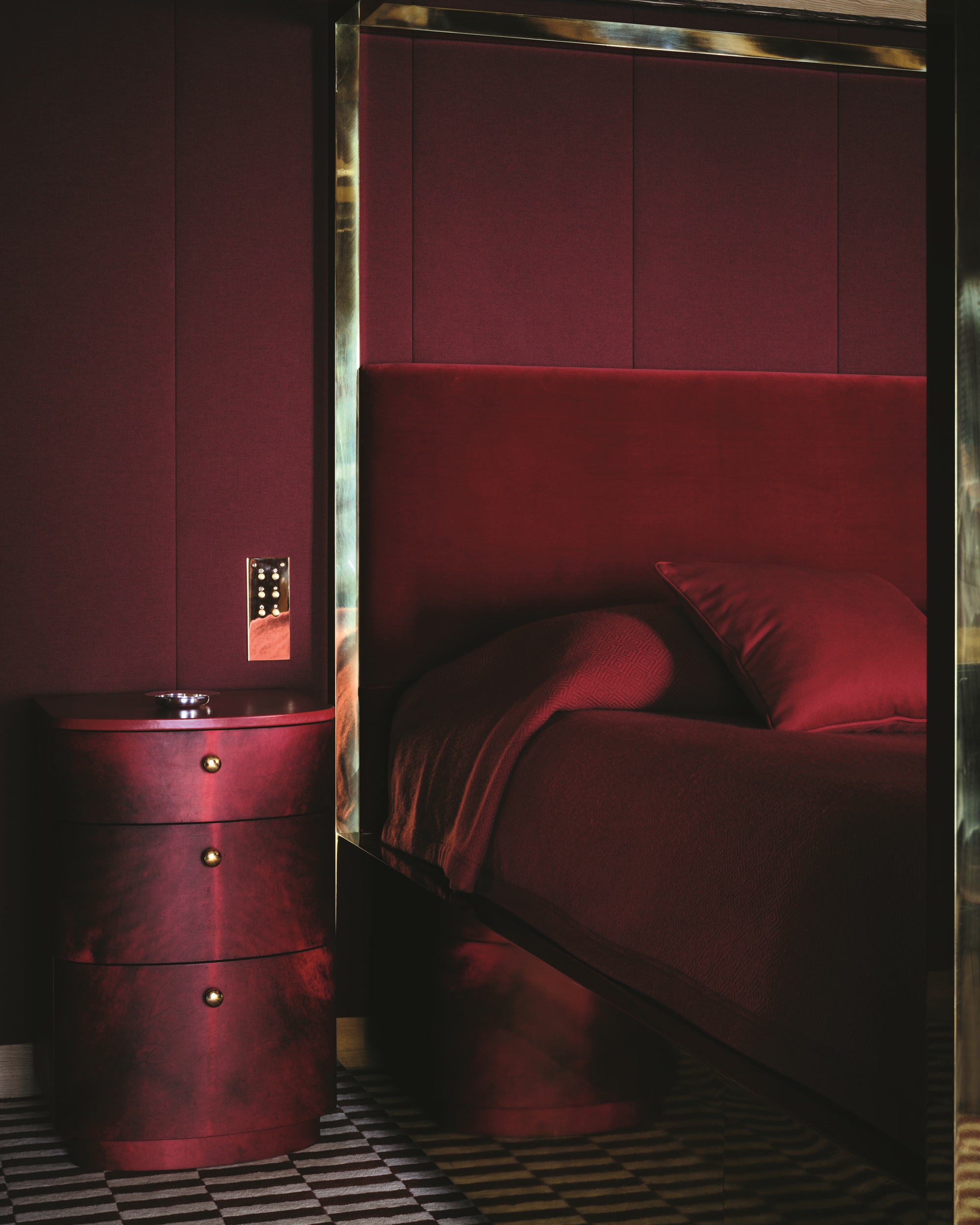 a red color drenched bedroom with a gold bed frame