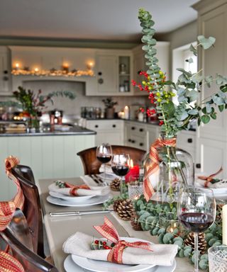Kitchen Christmas decor ideas with a table arrangement featuring eucalyptus and pine cones