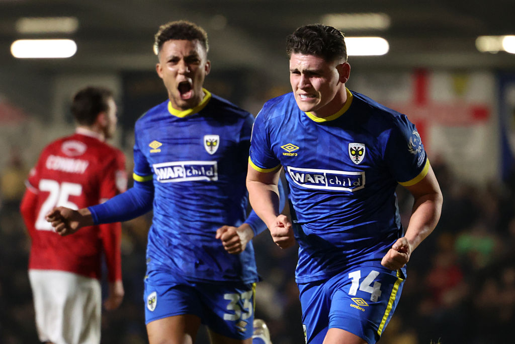 Matty Stevens of AFC Wimbledon celebrates scoring his team's first goal with teammate Isaac Ogundere during the Sky Bet League Two match between AFC Wimbledon and Crewe Alexandra at The Cherry Red Records Stadium on February 11, 2025 in Wimbledon, England.