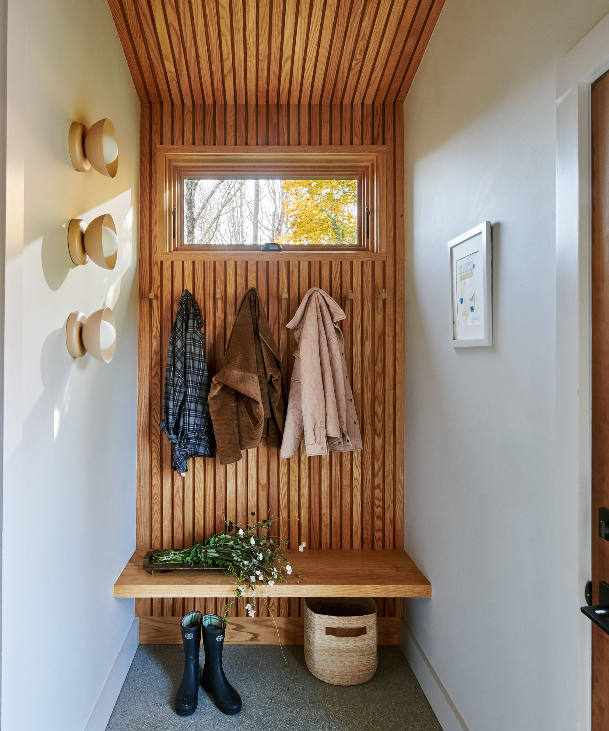 mudroom with wood slats on the wall and coats hanging from hooks