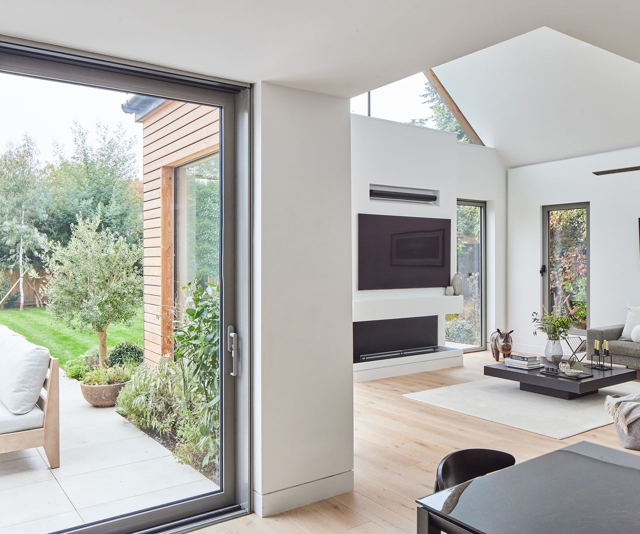 An L shaped living area with large glass sliding doors and a view out to the patio