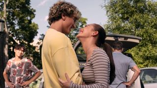 Jeremiah and Belly embrace as her family unpack their car behind them