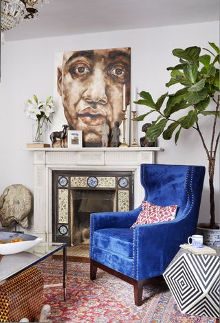 living room with blue velvet chair and painting