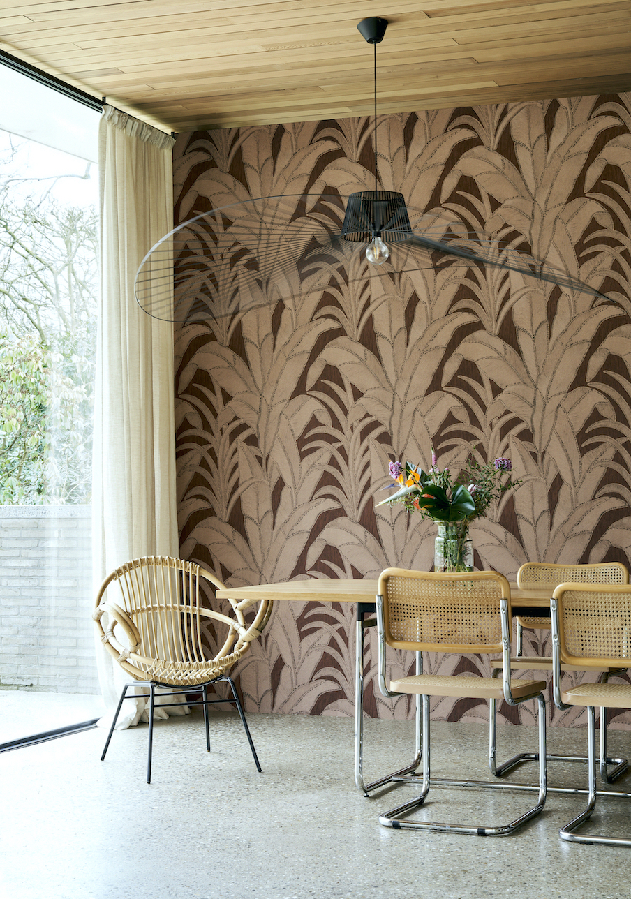 dining room with bold leaf wallpaper, wooden table, rattan chairs, tiled floor