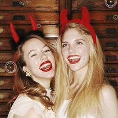 Two woman in Halloween costumes with horns