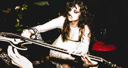 Demi Demitro of the Velveteers places her guitar in the hands of the crowd 