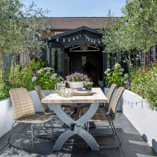 outdoor dinning table and chairs with plants