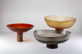 Different sized glass bowls sitting on top of wooden plinths