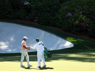 Brooks Koepka on the green at Augusta National with his caddie