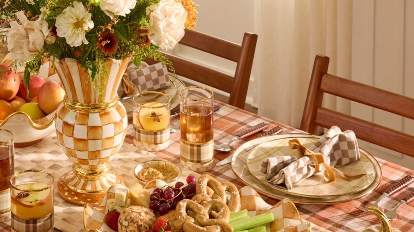 Fall table with red plaid tablecloth, orange and white check vase, and mocha check napkins