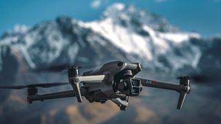 DJI Air 3 drone in flight with snow capped mountain background