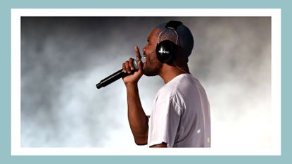 Frank Ocean pictured wearing headphones and holding a microphone as he performs at the 2017 Panorama Music Festival on Randall's Island in New York on July 28, 2017/ in a green/blue template