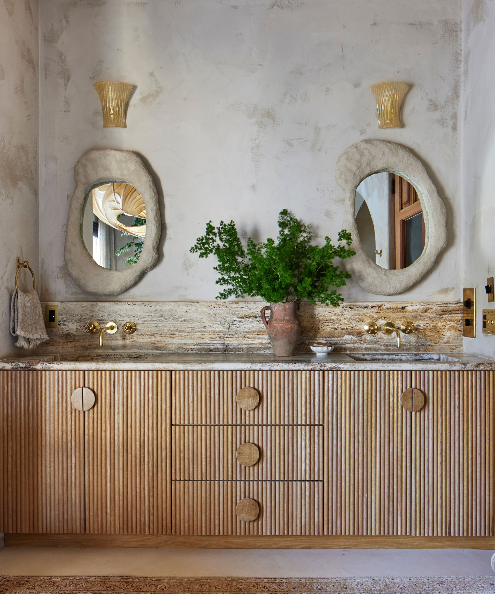 A Mediterranean bathroom with plaster limewash walls and a wooden bathroom vanity