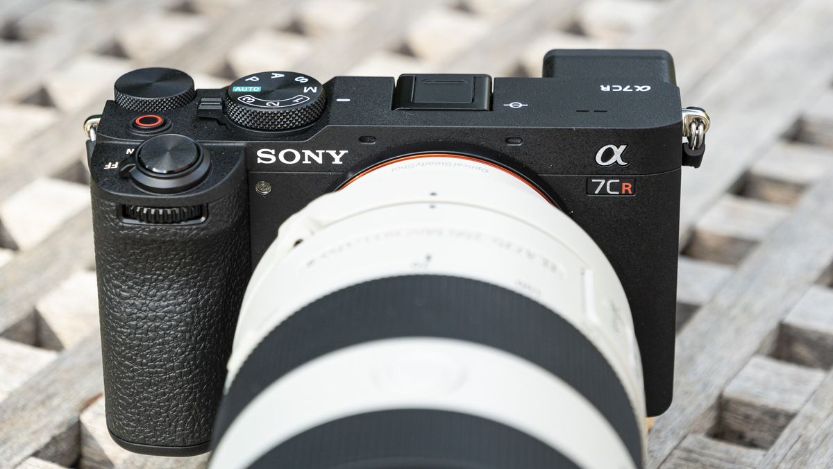 Sony A7C R mirrorless camera outside on a wooden table with FE 70-200mm F4 II lens attached