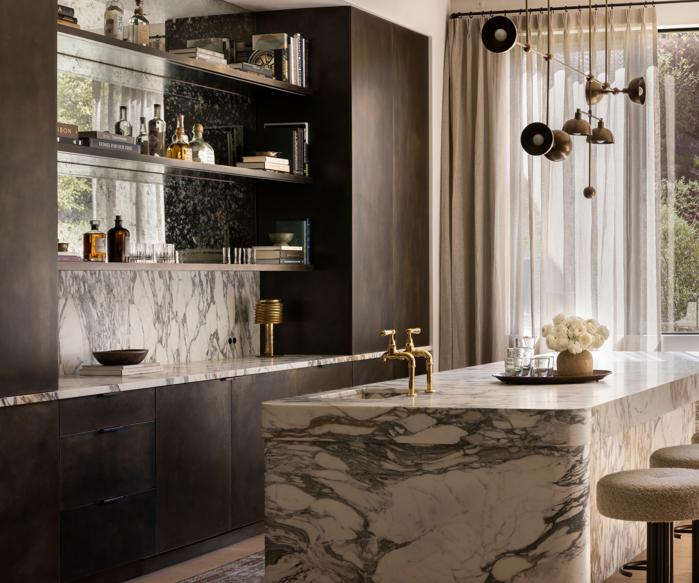A small kitchen with dark wood cabinets and a bold marble-drenched island
