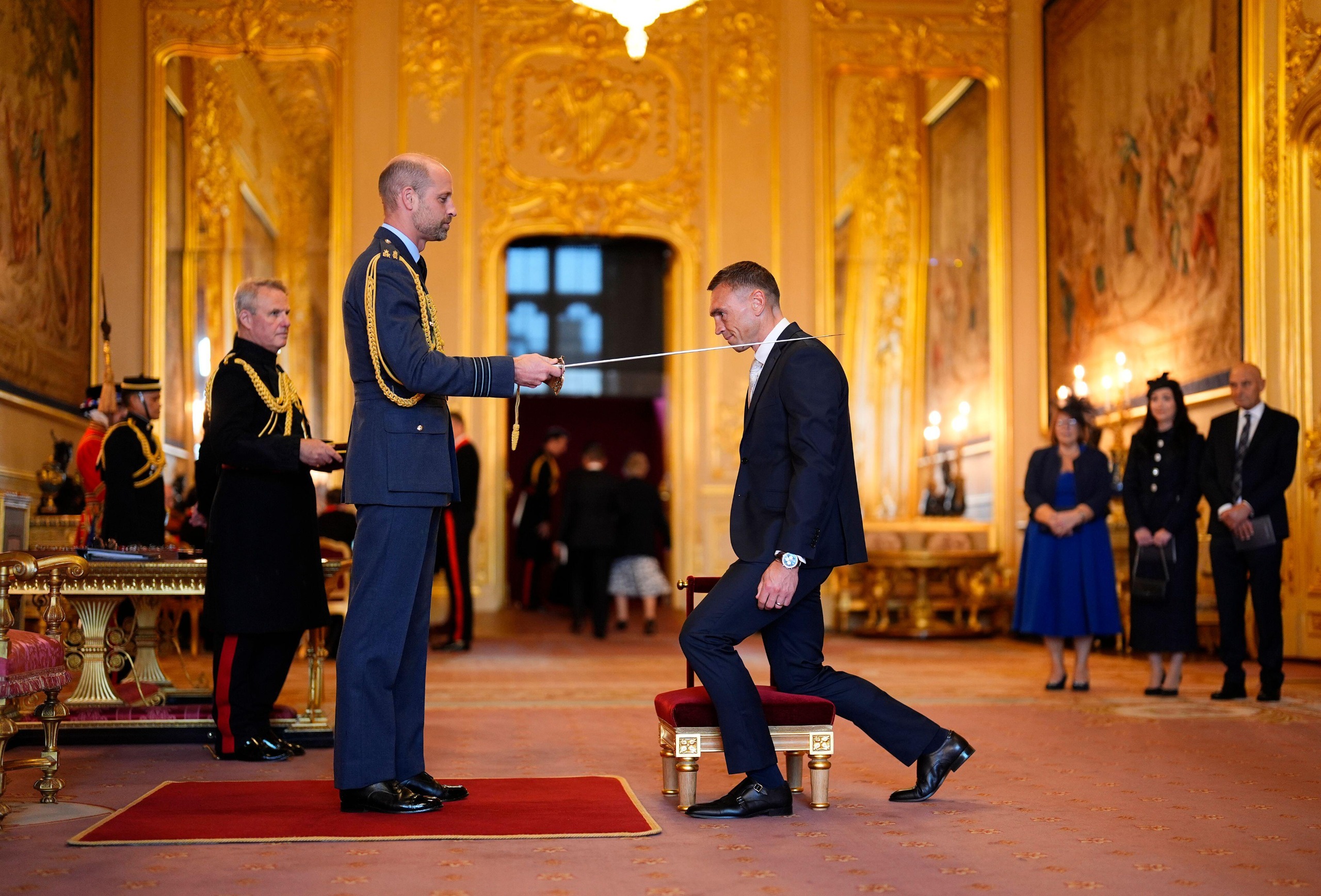 Prince William knighting Sir Kevin Sinfield in a room at Windsor Castle