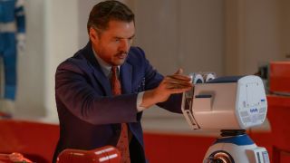 Pedro Pascal carefully loading a data tape into HERBIE in The Fantastic Four: First Steps.