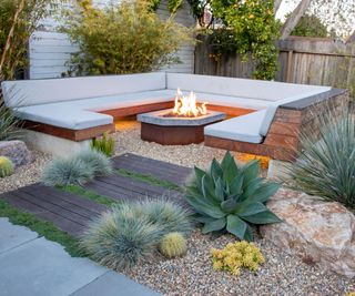 gravel garden with outdoor corner sofa and central fire pit