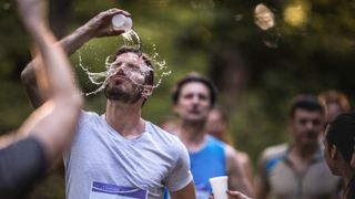 Marathon runner pouring water on himself