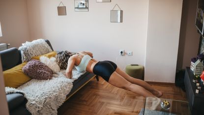 Woman doing an incline push-up on a sofa.