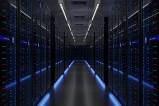 A stock image of a data center server room with dark colored servers featuring blue lights