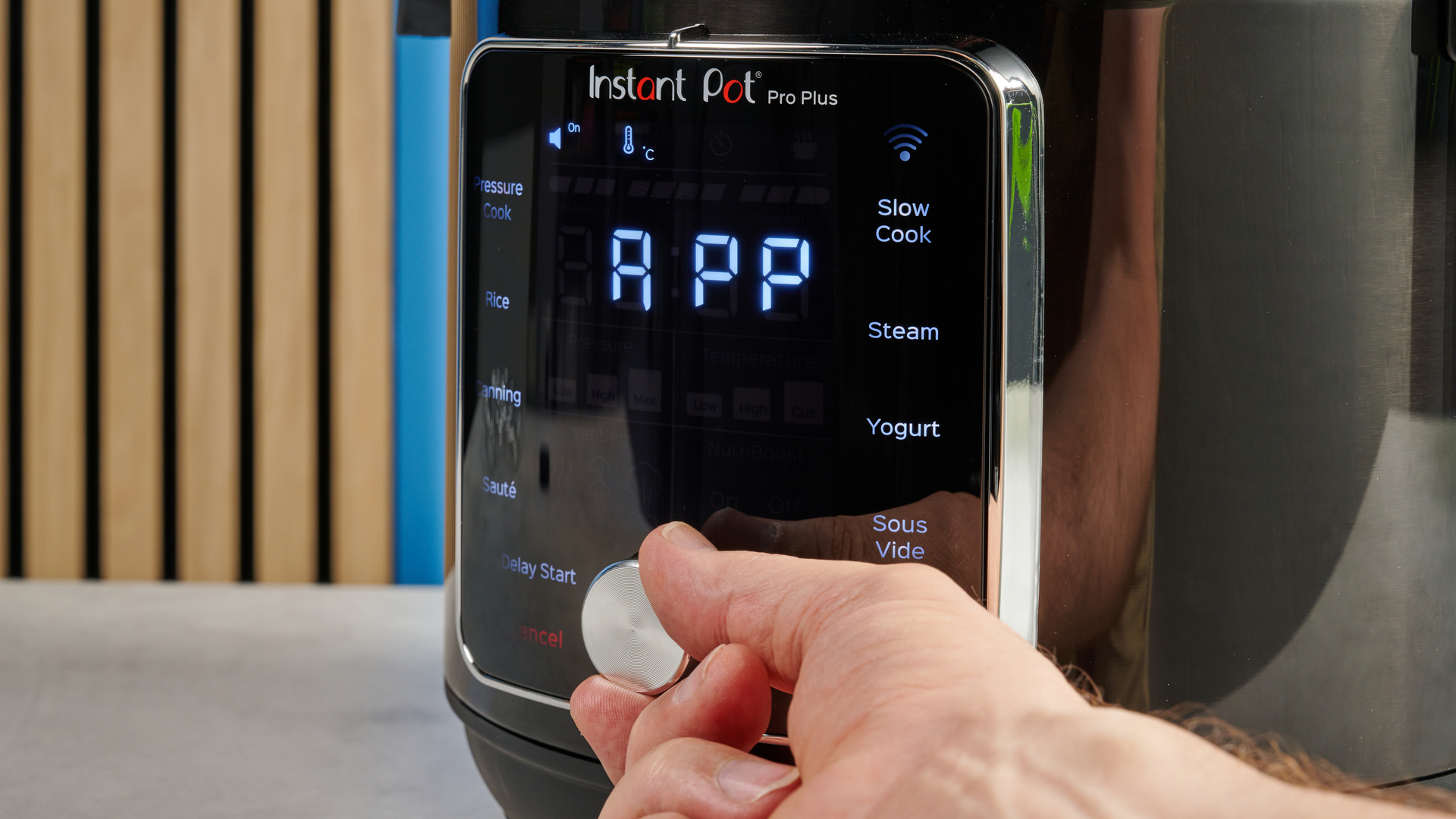 a black smart home enabled wi-Fi instant pot with a touchscreen and a 6QT inner pot is photographed against a blue background