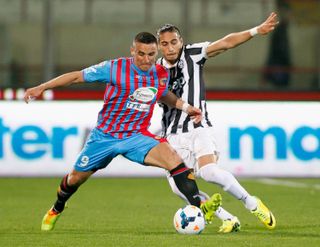 Gonzalo Bergessio of Catania competes for the ball with Martin Caceres of Juventus during a 2014 Serie A match