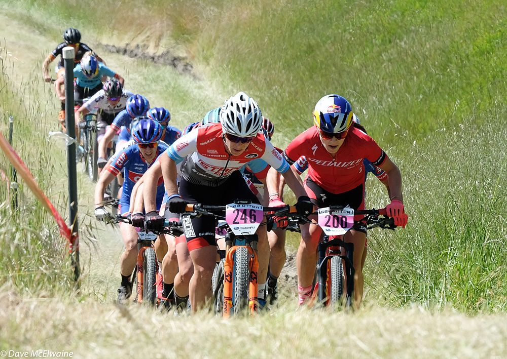 Chloe Woodruff (Stans-Pivot) leading mid-race with Kate Courtney to her left.