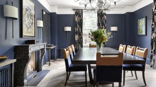 Dining room color ideas with navy walls, white ceilings, marble fireplace and orange dining chairs