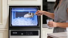 A woman using an ice making machine from VEVOR.