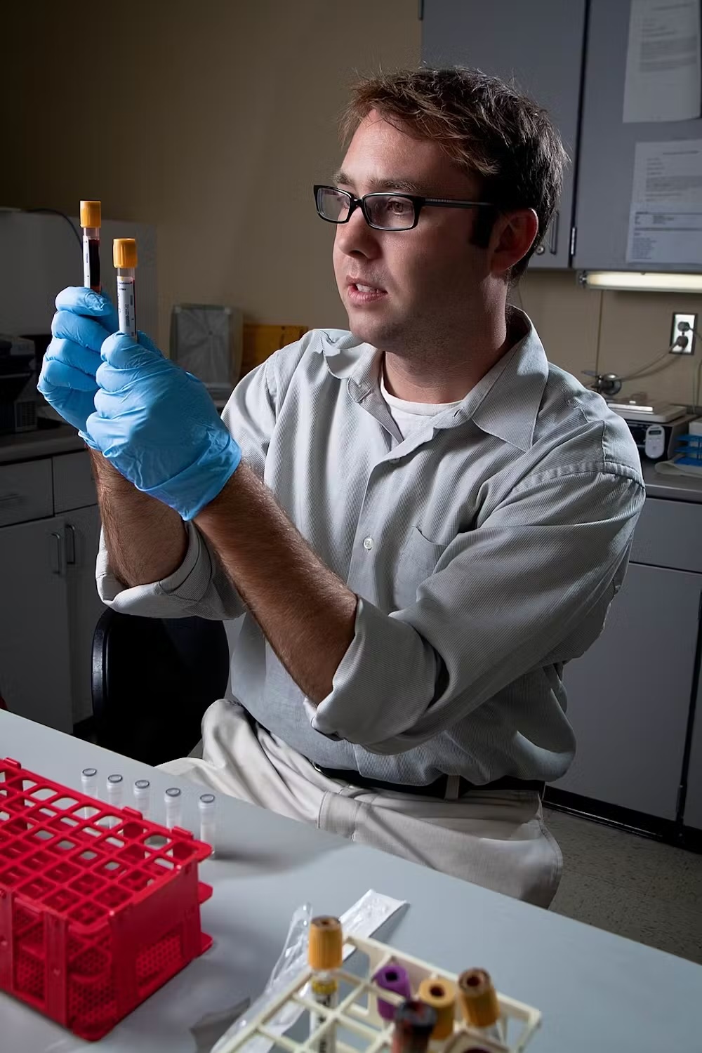 a lab worker holds vials of blood