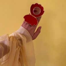 Photo of a woman looking into a compact mirror 