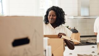Woman packing boxes ready to move in her kitchen